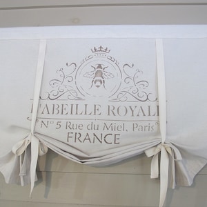 May include: A white fabric valance with a brown stencil design featuring a bee, a crown, and the text "L'ABEILLE ROYALE N° 5 Rue du Miel, Paris FRANCE".