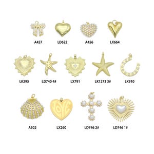 May include: A collection of gold-colored pendants in various shapes, including hearts, stars, a seashell, and a cross. Some pendants are adorned with pearls. Each pendant has a unique code, such as A457 and LX260.