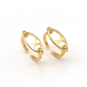 May include: Two gold-toned rings with an oval shape and a cutout design. The rings are open and adjustable.