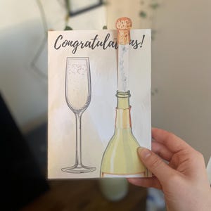 Carte de voeux pop-up félicitations - Bouchon de champagne interactif remplissant le verre - Carte de célébration pour les mariages, les remises de diplômes et les réalisations