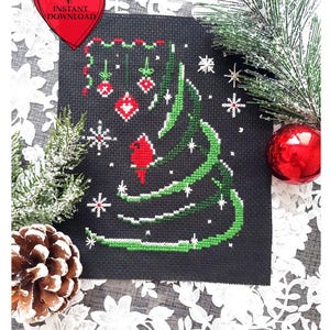 Puede incluir: Un diseño de árbol de Navidad bordado a punto de cruz sobre tela negra, con puntadas verdes y blancas. Adornos rojos y copos de nieve están esparcidos alrededor del árbol. Un corazón rojo con las palabras "INSTANT DOWNLOAD" está en la esquina superior izquierda.