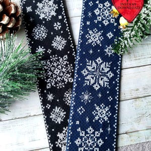 Puede incluir: Dos marcapáginas de tela, uno negro y otro azul marino, ambos adornados con patrones de copos de nieve blancos. Los marcapáginas rectangulares presentan intrincados diseños bordados. La imagen incluye decoraciones navideñas, lo que sugiere un tema estacional.