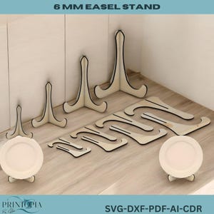 May include: Six wooden easel stands of varying sizes, made of 6 mm thick wood, are arranged on a light wood surface. The stands are designed to hold pictures or other items upright. The text "6 MM EASEL STAND" is printed at the top of the image. The text "SVG-DXF-PDF-AI-CDR" is printed at the bottom of the image.