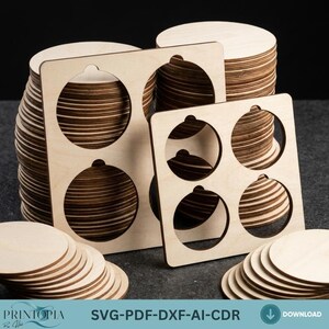 Op de afbeelding: Stapels onafgewerkte houten kerstornamenten en -houders. De houders hebben uitgesneden vormen voor de ornamenten. De afbeelding bevat ook stapels individuele houten cirkels. De tekst "SVG-PDF-DXF-AI-CDR" is zichtbaar.
