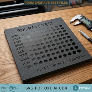 May include: A square black foam sheet featuring an engraved test grid with circular indentations. The text "ENGRAVE TEST" is at the top, with numerical values ranging from 1000 to 7000 on the left and 10 to 40 along the bottom edge.