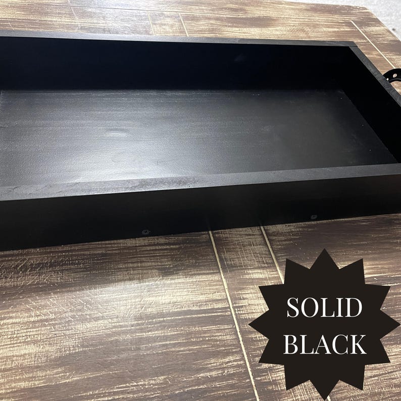Puede incluir: Una bandeja rectangular de madera negra maciza con un perfil bajo. La bandeja tiene un acabado liso y mate y est&aacute; colocada sobre una superficie de madera. El texto "SOLID BLACK" se muestra en forma de estrella negra.