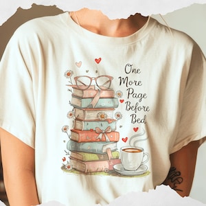以下が含まれることがあります： クリーム色のTシャツ。本、メガネ、デイジー、ハートのイラスト。コーヒーカップと「One More Page Before Bed」の文字が描かれています。本好きにぴったりの、可愛らしいグラフィックTシャツです。