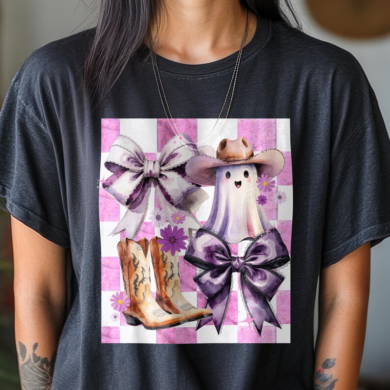 May include: Black t-shirt featuring a watercolor design with a ghost wearing a cowboy hat and a large purple bow. The design includes cowboy boots, bows, and flowers on a pink and white checkered background.