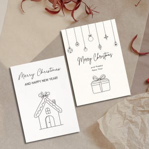 K&ouml;nnte beinhalten: Zwei druckbare Weihnachtskarten mit schwarzen Linienzeichnungen. Eine Karte zeigt ein Lebkuchenhaus mit dem Text "Frohe Weihnachten und ein gutes neues Jahr!" Die andere Karte zeigt eine Geschenkbox mit Schleife und dem Text "Frohe Weihnachten und ein gutes neues Jahr".