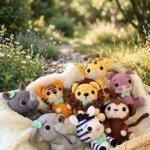 Può includere: Una collezione di sette piccoli animali di peluche all'uncinetto tra cui un rinoceronte grigio, una tigre arancione, una giraffa gialla, un orso rosa, un elefante grigio, una zebra bianca e nera e una scimmia marrone, tutti con fiocchi verde menta.