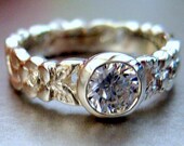Engagement ring.  White sapphire in the center.  Leaf design