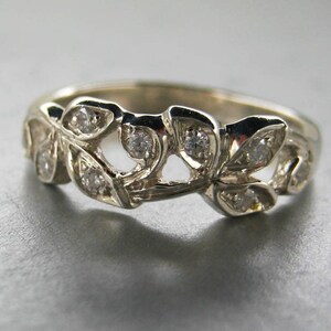 Puede incluir: Un anillo de plata con un delicado dise&ntilde;o de hojas y peque&ntilde;os diamantes.