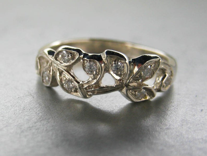 Puede incluir: Un anillo de plata con un delicado dise&ntilde;o de hojas y peque&ntilde;os diamantes.