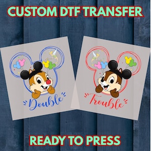 May include: Two gray DTF transfer sheets featuring Chip from Chip 'n Dale. One has a blue Mickey Mouse head outline with the word "Double" and the other has a red outline with the word "Trouble". Both have the text "CUSTOM DTF TRANSFER" and "READY TO PRESS".