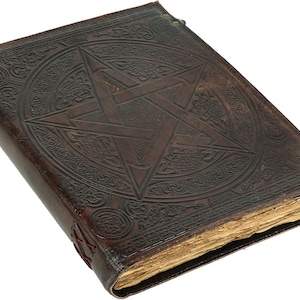 Könnte beinhalten: Ein dunkelbraunes, ledergebundenes Buch mit einem geprägten Pentagramm-Design auf dem Einband. Der Einband zeigt auch komplizierte keltische Knotenmuster und kreisförmige Muster. Die gealterten Seiten deuten auf den Vintage-Charakter des Buches hin.