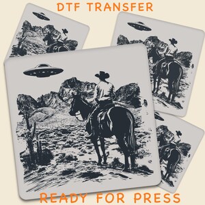 May include: A DTF transfer design showing a cowboy riding a horse, with a UFO overhead. The design is monochrome, set against a desert backdrop. The text "DTF TRANSFER" and "READY FOR PRESS" are displayed in orange.