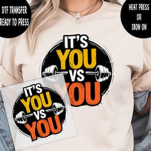 May include: A beige t-shirt featuring a DTF transfer design with the text "IT'S YOU VS YOU" in yellow and orange, with a barbell graphic. The words "DTF TRANSFER READY TO PRESS" and "HEAT PRESS OR IRON ON" are also visible.