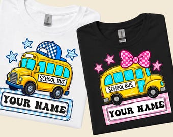 May include: A white t-shirt and a black t-shirt, each featuring a yellow school bus graphic. The white shirt bus wears a blue checkered cap, while the black shirt bus has a pink checkered bow. Both include the text SCHOOL BUS and YOUR NAME.