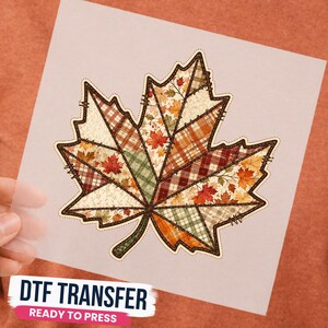 May include: A DTF transfer featuring a large maple leaf design composed of various patchwork segments. The segments display autumn-themed patterns including plaid, gingham, and small maple leaves in shades of orange, red, brown, and green.