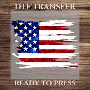 May include: DTF transfer featuring a distressed American flag design. The flag has a watercolor effect with red and white stripes, a blue field with white stars. The text "DTF TRANSFER" is at the top, and "READY TO PRESS" at the bottom.