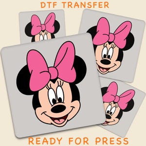 Peut inclure: Transferts DTF avec le visage de Minnie Mouse orné d'un nœud rose. Le motif est sur un fond carré gris, avec les mots "DTF TRANSFER" et "READY FOR PRESS" en orange.