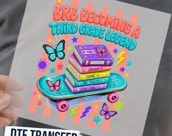 May include: A DTF transfer sheet featuring a graphic with the text BRB BECOMING A THIRD GRADE LEGEND. The design includes a stack of colorful books on a teal skateboard, surrounded by butterflies, stars, and lightning bolts in vibrant colors.