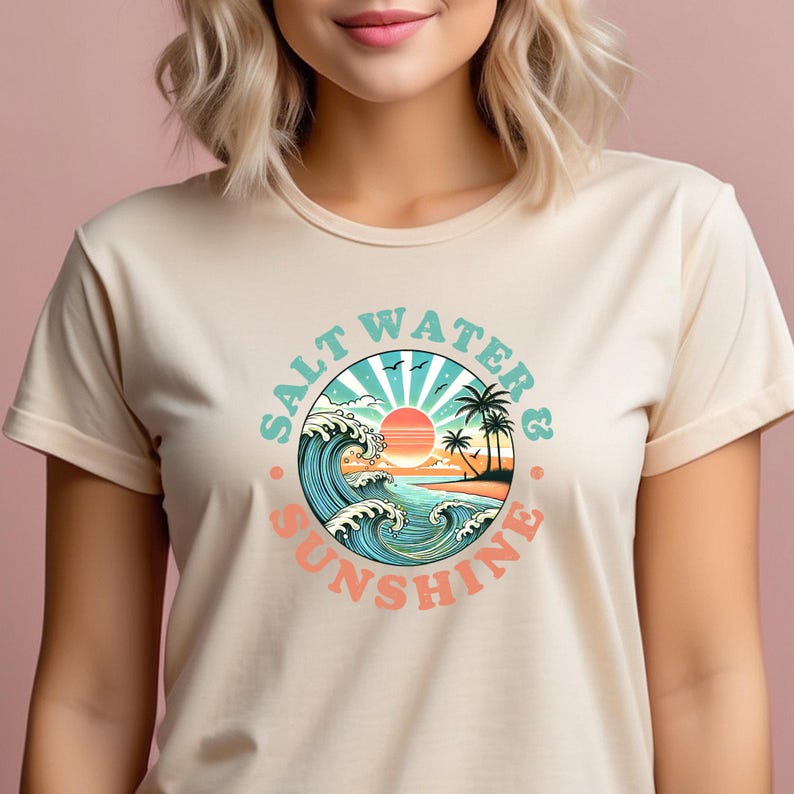 May include: A beige t-shirt with a graphic print of a sunset over the ocean with waves and palm trees. The text "Salt Water & Sunshine" is in a circle around the graphic.