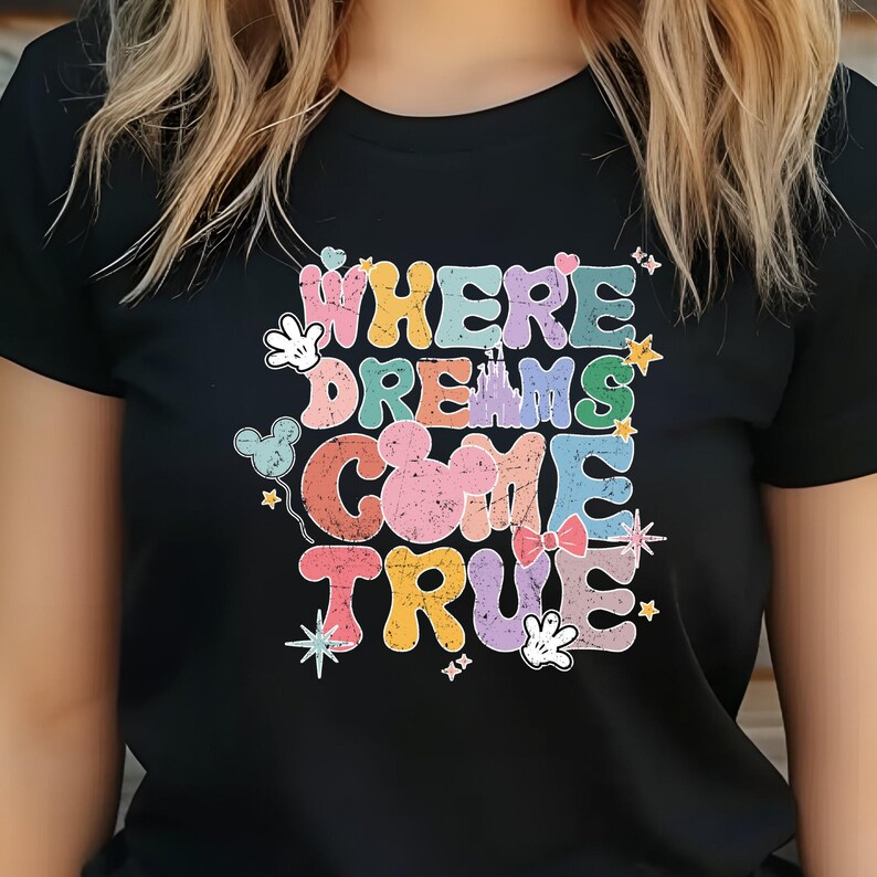 May include: Black t-shirt with a colorful graphic that says "Where Dreams Come True" with Mickey Mouse and other Disney characters.