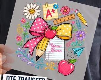 May include: A DTF transfer sheet featuring a school-themed graphic with a large pink polka-dot bow, a yellow pencil, two red apples, a notepad with the text Your Name, a ruler, a yellow A+ note, a paper airplane, and colorful floral accents.