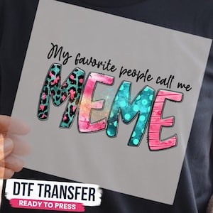 May include: A DTF transfer sheet featuring the black text My favorite people call me MEME. The word MEME is in large, stylized letters with a colorful design: the M has a teal and pink leopard print, the E has a pink watercolor texture, the M has a teal polka dot pattern, and the E has pink horizontal stripes.