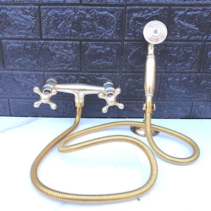 Brass handheld shower system with solid construction and versatile hand shower functionality.