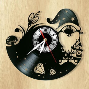 May include: Black vinyl record clock featuring a gnome holding a lantern, with a mushroom, flower, and diamonds around the clock face.
