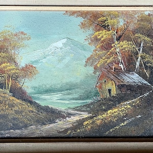 May include: A painting of a rustic cabin nestled in a forest with a snow-capped mountain in the background. The scene is painted in warm, earthy tones with hints of blue and green.
