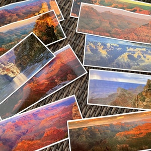 May include: A collection of Grand Canyon postcards featuring various scenic views of the canyon, including the Colorado River, layered rock formations, and distant mountain ranges.