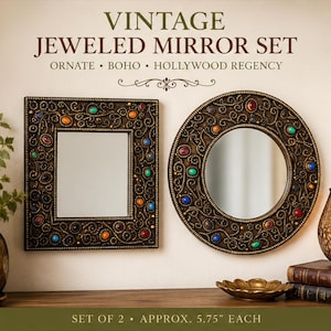 May include: A set of two wall mirrors, one square and one circular, featuring dark bronze frames with intricate scrollwork and embedded multicolored cabochon jewels. The text VINTAGE JEWELED MIRROR SET ORNATE BOHO HOLLYWOOD REGENCY is visible above the mirrors.