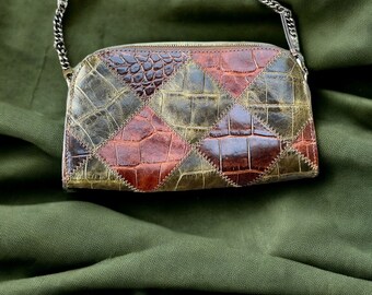 Versatile Clutch of embossed croc leather in a patchwork pattern featuring zig-zag stitch detail