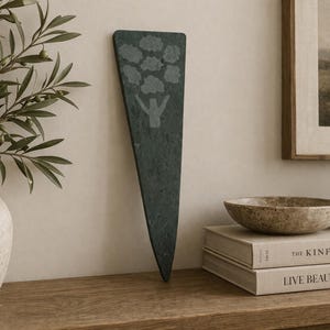 May include: A white ceramic mug with a black handle and the text "But First, Coffee" in a bold, black font. The mug is sitting on a wooden surface. The mug is approximately 4 inches tall.