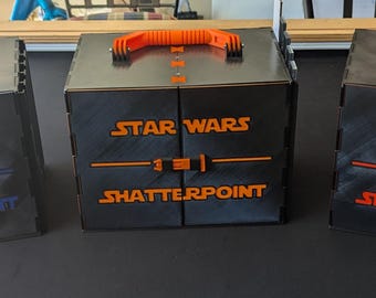 May include: Three black storage boxes with orange handles and the words "Star Wars Shatterpoint" printed on the front.