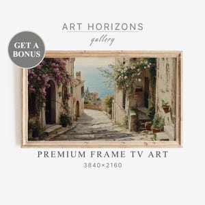 May include: A framed painting of a narrow, cobblestone street in a European village. The street is lined with buildings with terracotta roofs and flowering vines. The buildings are painted in shades of white and yellow. The street leads to a view of the ocean in the distance.