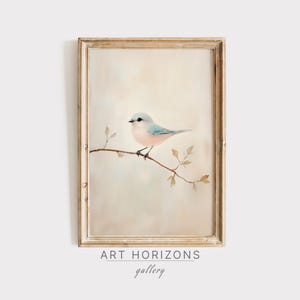 May include: A framed watercolour painting of a pale blue bird perched on a branch with delicate brown leaves. The background is a soft, muted beige.