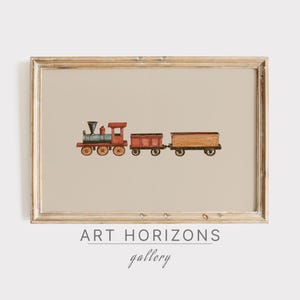 May include: A framed watercolor illustration of a red toy train with a blue engine and a brown boxcar. The train is on a beige background. The frame is light wood with a white mat. The text "ART HORIZONS gallery" is below the frame.
