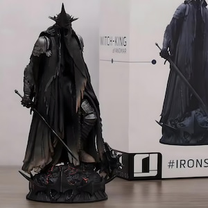 May include: A black Witch-King of Angmar statue with a long, flowing cloak and a spiked helmet, holding a sword. The figure stands on a detailed base with a fiery design. The box behind the statue has the text "WITCH-KING of ANGMAR".