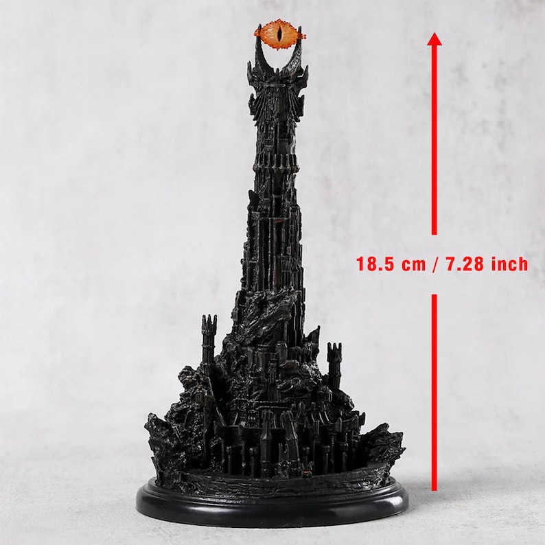 May include: A black miniature tower with an orange eye at the top, measuring 7.28 inches tall. The tower has intricate details and sits on a round base. The eye is a prominent feature.