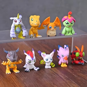 May include: A set of ten colorful plastic figurines of various Digimon characters. The figurines are approximately 2 inches tall and feature detailed paint applications. The characters include Agumon, Gabumon, Greymon, and others.