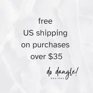 May include: A white and light gray marble-textured background featuring the black text "do dangle! DESIGNS" centered near the bottom. The design is clean and minimalist, focusing on the brand name presented in a combination of script and sans-serif fonts.
