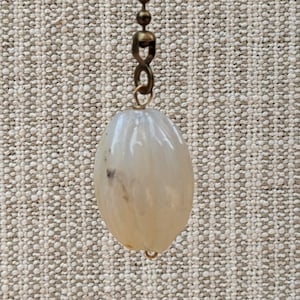May include: A white agate ceiling fan pull with a gold chain.