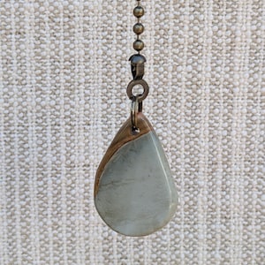 May include: A set of three ceramic mugs with a speckled, matte finish. The mugs are in shades of cream, light gray, and dark gray. Each mug has a simple, minimalist design, perfect for coffee or tea.