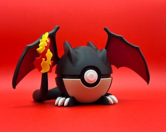 May include: A black and red 3D printed toy with a yellow and red flame design on one wing. The toy is shaped like a dragon and has a round, brown and black body with a white circle in the center.