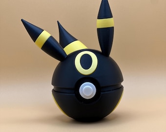 May include: Black and yellow 3D printed Pokemon figure of a Pokeball with a black and yellow Eevee head on top.