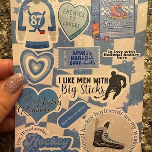 May include: A sticker sheet with a blue and white checkered pattern. It features hockey-themed stickers with text like "Hockey Romance" and "I Like Men With Big Sticks." Includes images of hockey skates and jerseys.